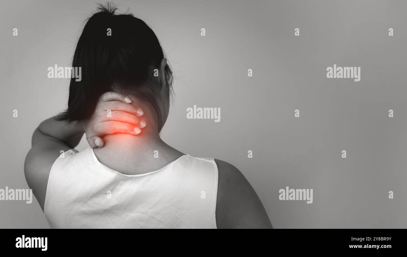 Femme avec une maladie aiguë de la colonne vertébrale de douleur avec douleur au cou sur fond gris, douleur au cou et traitement de la maladie de la colonne vertébrale, femme massant son spasme musculaire du cou, Banque D'Images