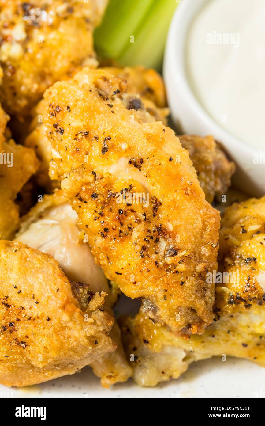 Ailes de poulet au citron et au poivre maison épicées avec fromage bleu Banque D'Images