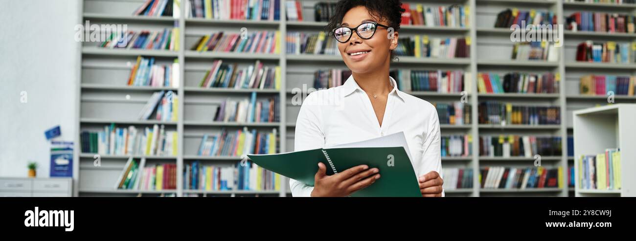 Un enseignant dévoué sourit tout en se préparant à une leçon engageante dans une salle de classe animée. Banque D'Images