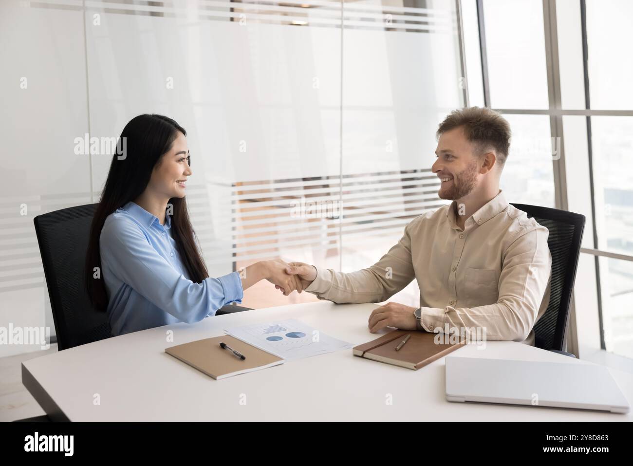 Heureux entrepreneurs multiethniques prospères se serrant la main à la réunion Banque D'Images