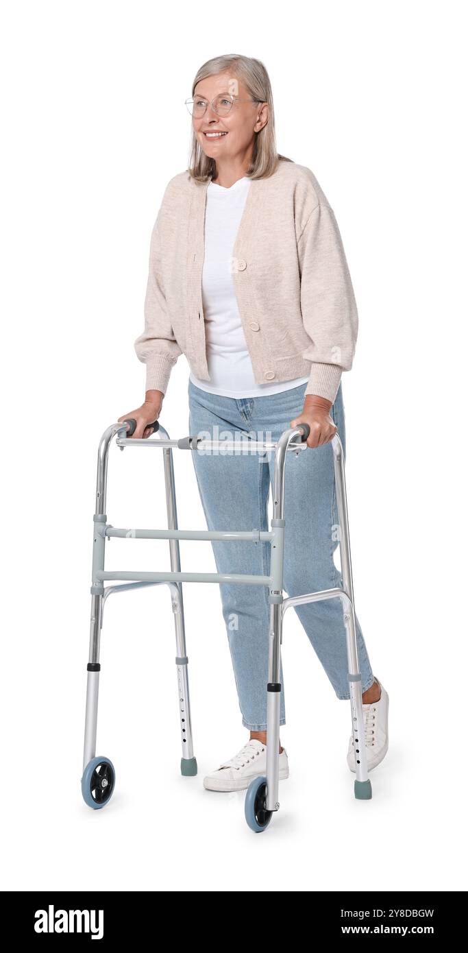 Femme senior utilisant le cadre de marche sur fond blanc Banque D'Images