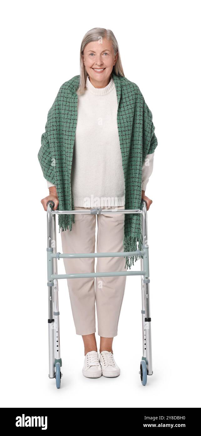 Femme senior utilisant le cadre de marche sur fond blanc Banque D'Images