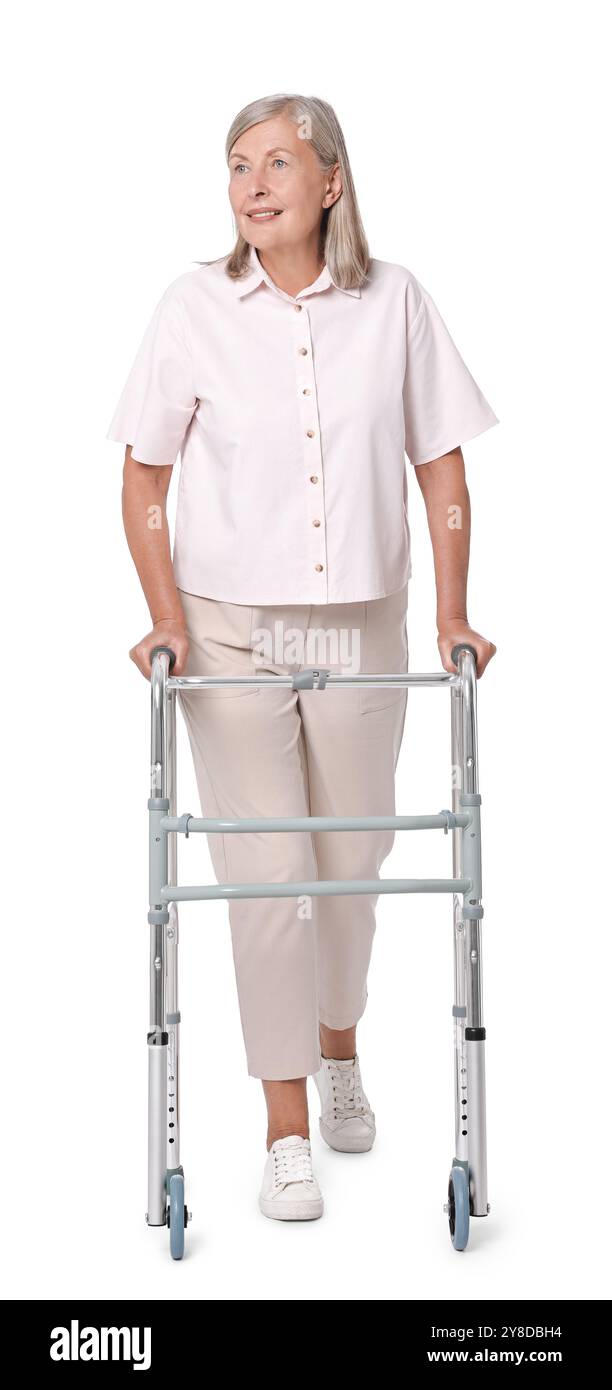 Femme senior utilisant le cadre de marche sur fond blanc Banque D'Images