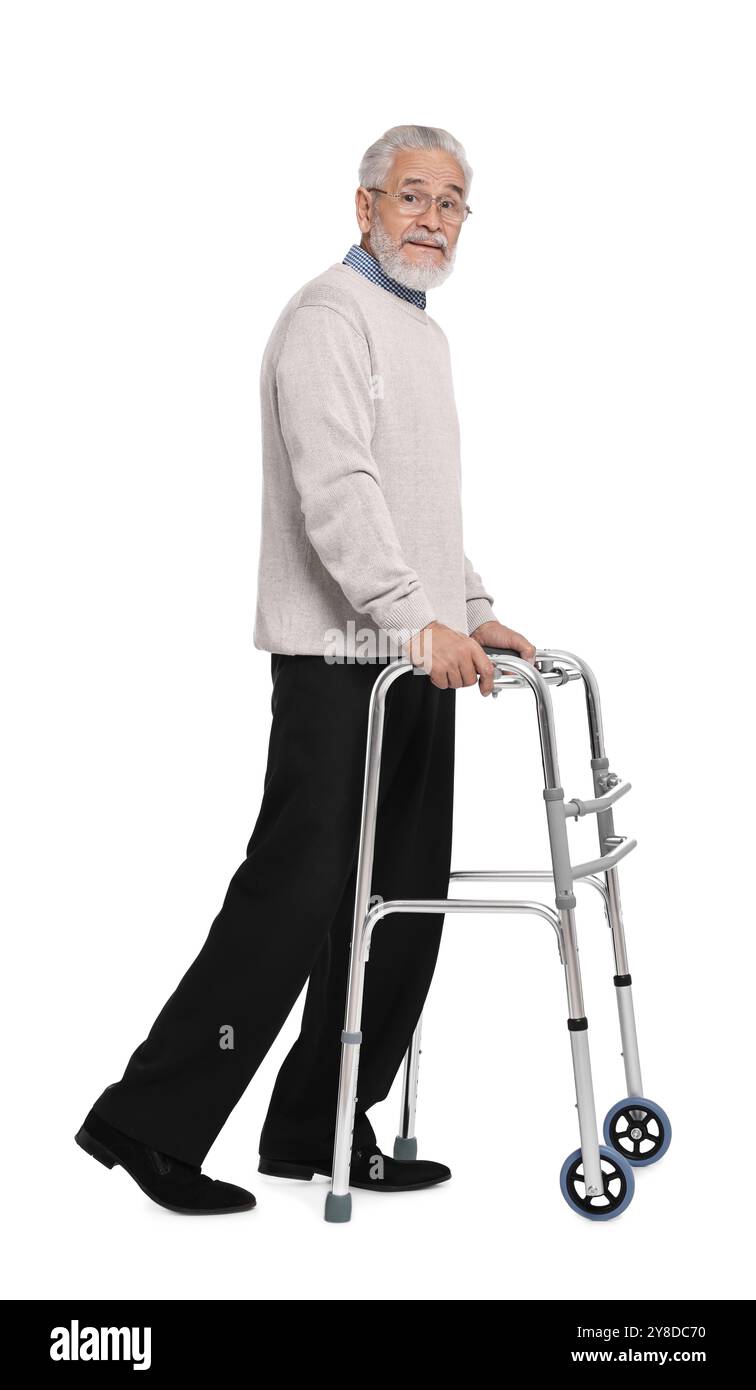 Homme senior utilisant le cadre de marche sur fond blanc Banque D'Images