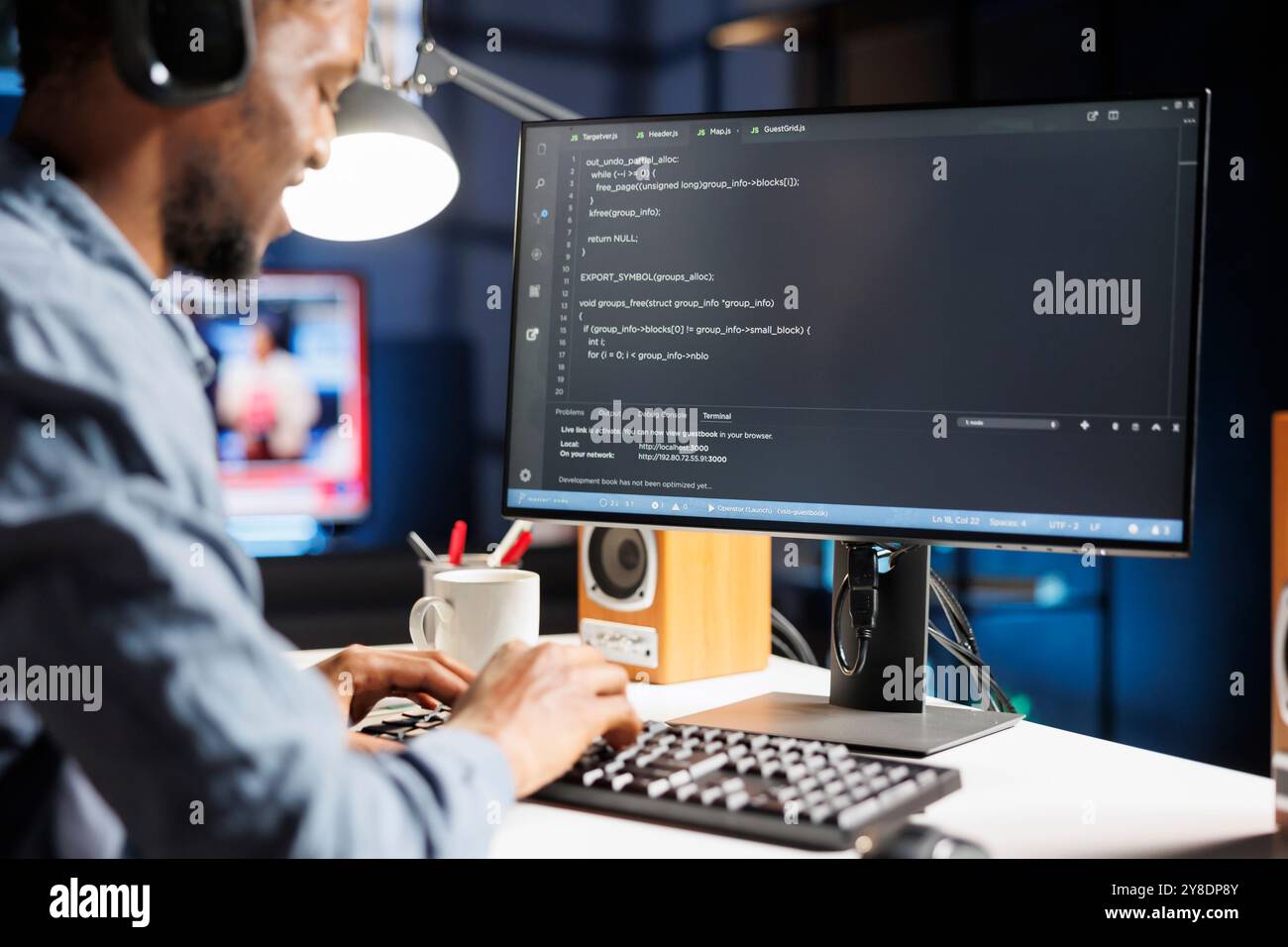 Sur la fenêtre du terminal, le programmeur internet afro-américain écrit le code du serveur en langage binaire et machine. Résolution des problèmes de sécurité des bases de données en tant que jeune ingénieur réseau, télétravail. Banque D'Images