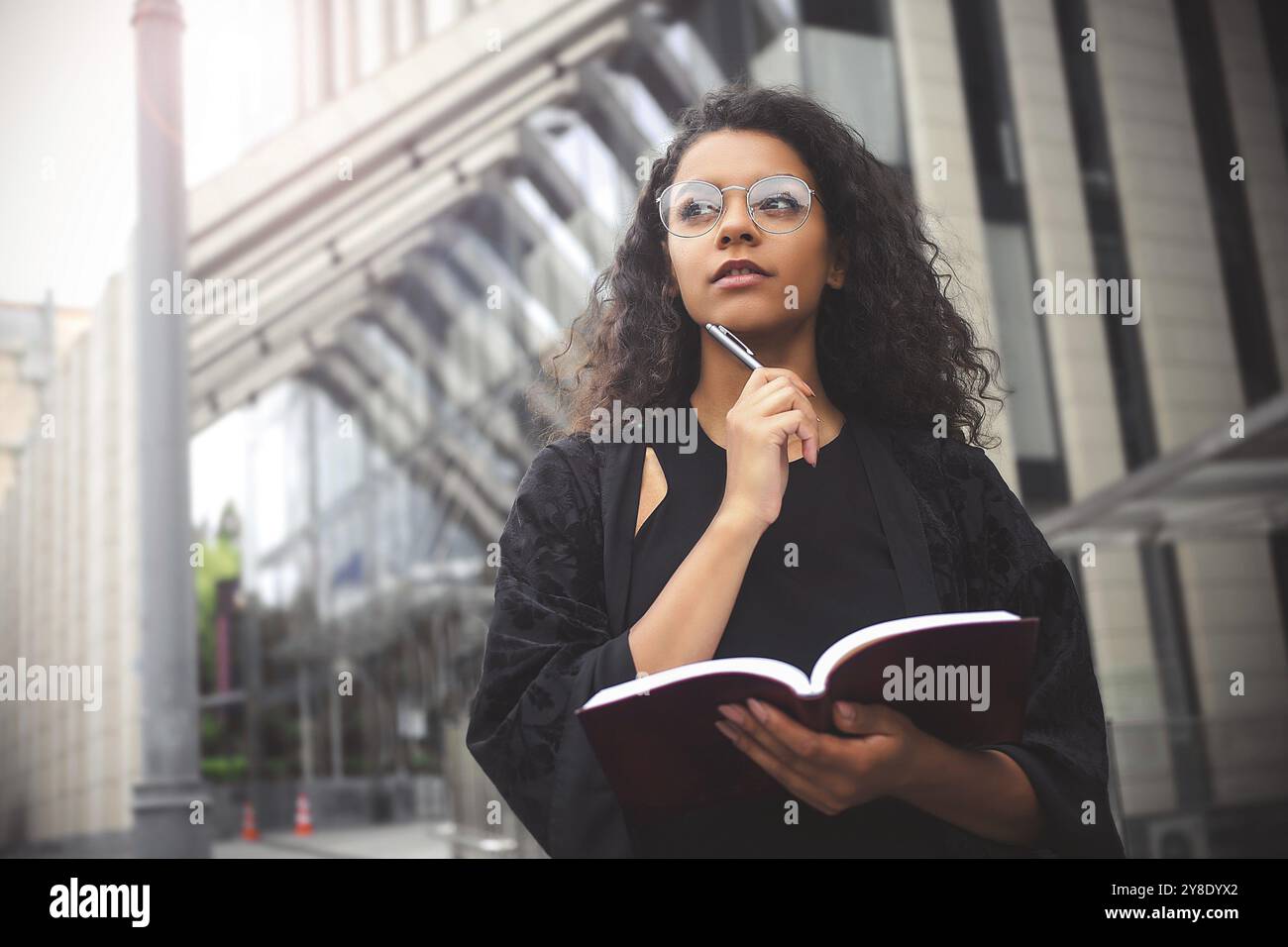Entrepreneure indépendante mixte occupée à écrire dans son cahier Banque D'Images