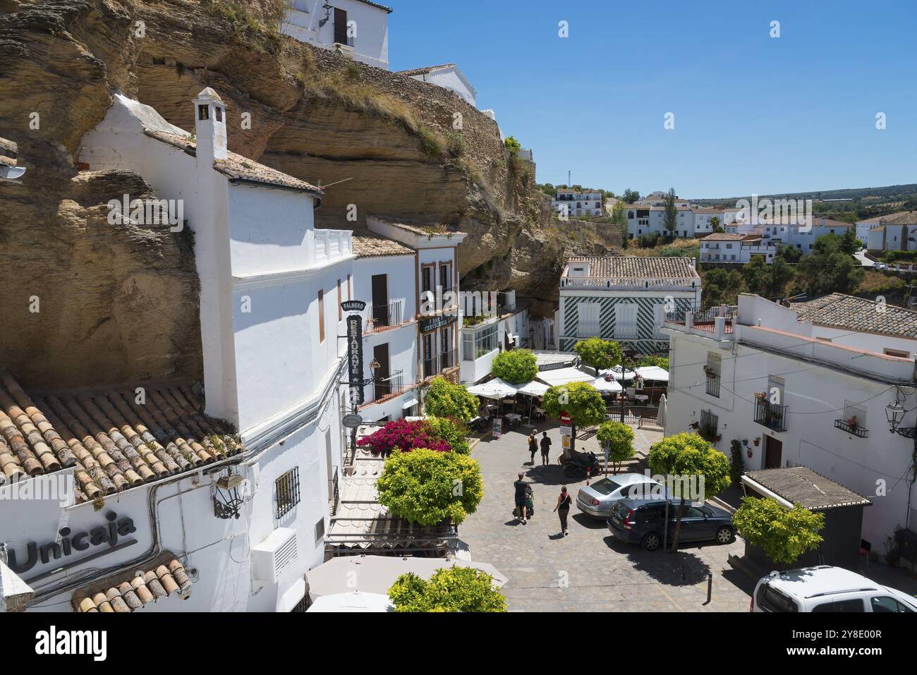 Place avec des voitures et des cafés à Setenil de las Bodegas sous les rochers avec des maisons blanches, ciel bleu, maisons de grotte, Setenil de las Bodegas, Cadix, Andalusi Banque D'Images