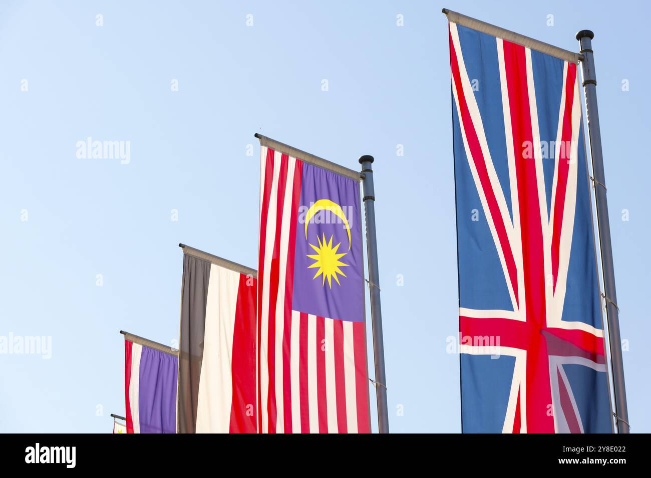 Divers drapeaux nationaux flottent sur des mâts de drapeau contre un ciel bleu, drapeau malaisien, drapeau anglais, drapeau égyptien Banque D'Images