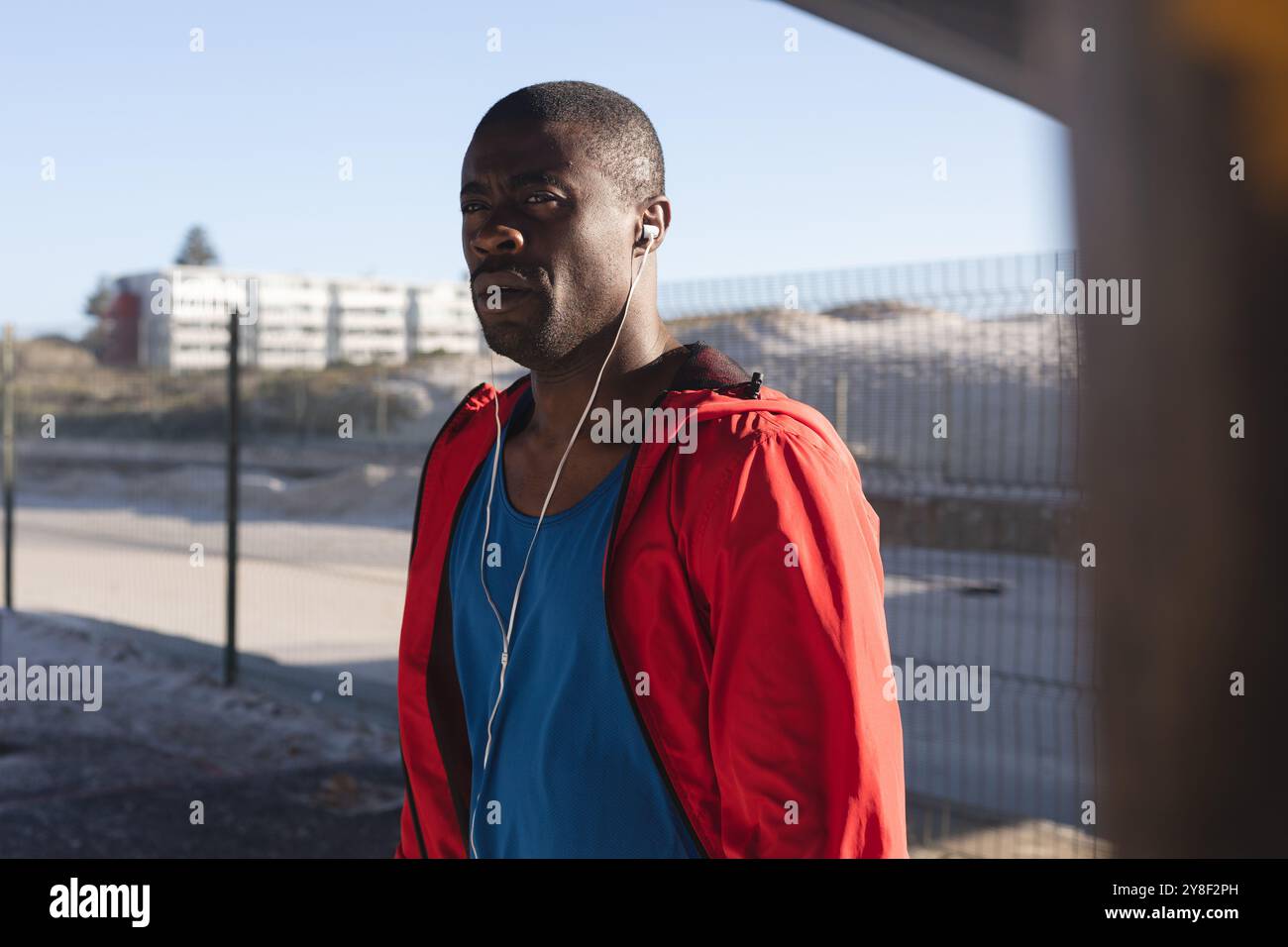 Homme afro-américain faisant de l'exercice en plein air, portant des écouteurs, écoutant de la musique Banque D'Images