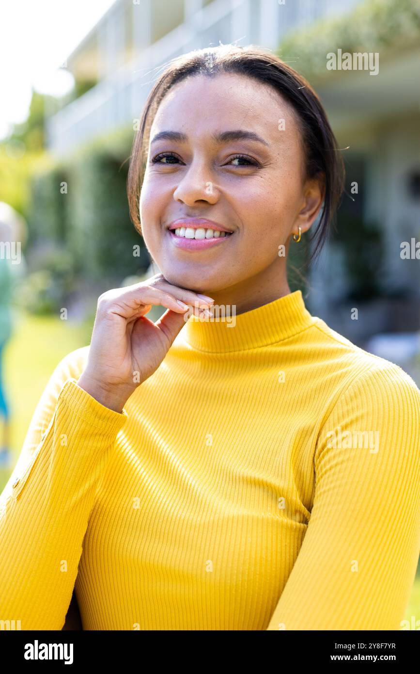 Portrait de femme biraciale heureuse regardant la caméra dans le jardin Banque D'Images