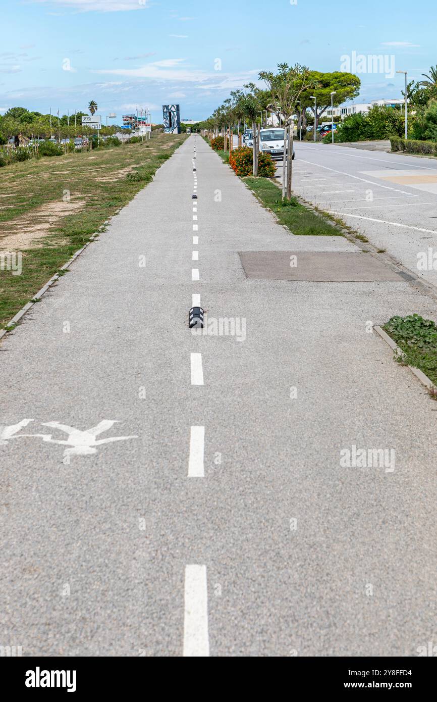 Une longue piste cyclable et pédestre droite au Barcares, dans le sud de la France. Banque D'Images Une longue piste cyclable et pédestre droite au Barcares, dans le sud de la France. Banque D'Images