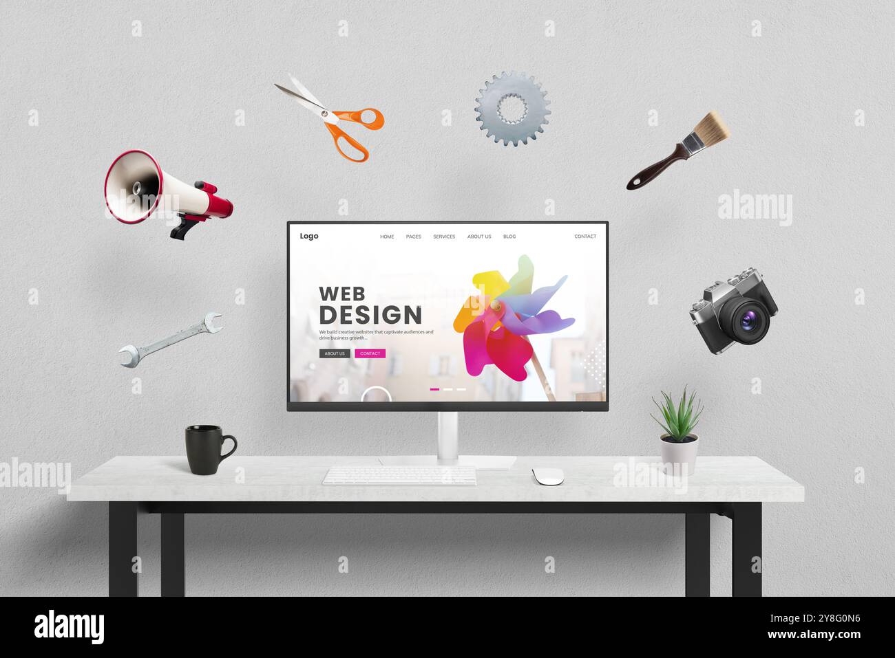 Page de concept de conception Web affichée sur l'ordinateur en studio, entouré par des outils créatifs, marketing et de bureau volant autour. Concept de la créatrice pr Banque D'Images