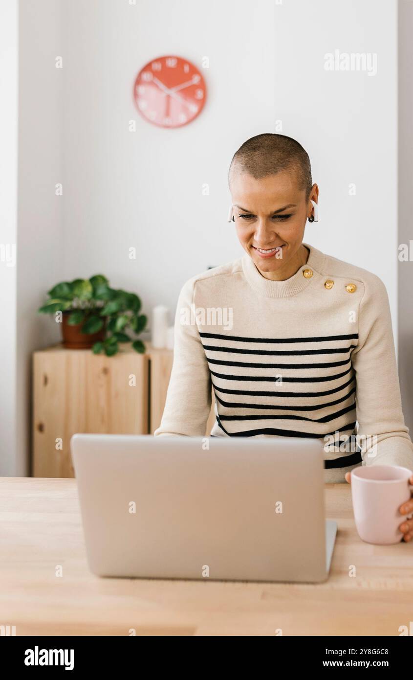 Femme adulte moyenne heureuse travaillant sur un ordinateur portable ayant un appel vidéo à la maison Banque D'Images Femme adulte moyenne heureuse travaillant sur un ordinateur portable ayant un appel vidéo à la maison Banque D'Images