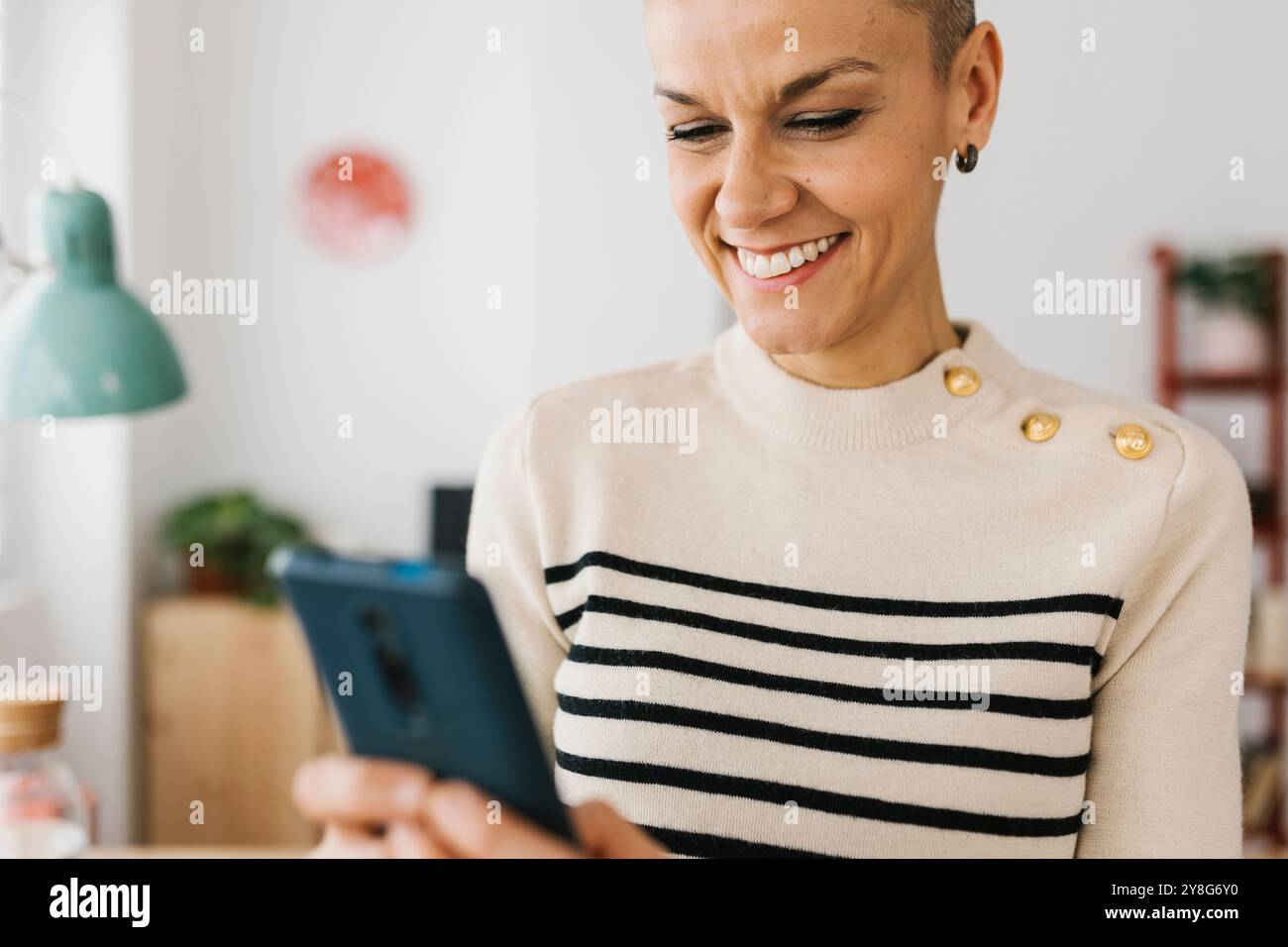 Femme d'affaires adulte moyenne utilisant un téléphone intelligent tout en travaillant sur ordinateur portable dans le bureau Banque D'Images Femme d'affaires adulte moyenne utilisant un téléphone intelligent tout en travaillant sur ordinateur portable dans le bureau Banque D'Images