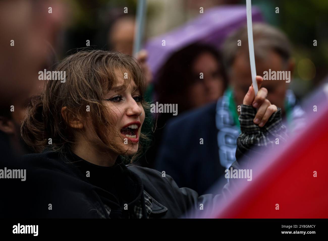 Une femme assiste à une manifestation de soutien à la Palestine et contre les actions de guerre israéliennes dans la bande de Gaza, en Cisjordanie et au Liban sur la place principale de la vieille ville de Cracovie. Des drapeaux palestiniens et des pancartes pro-palestiniens sont vus. Banque D'Images