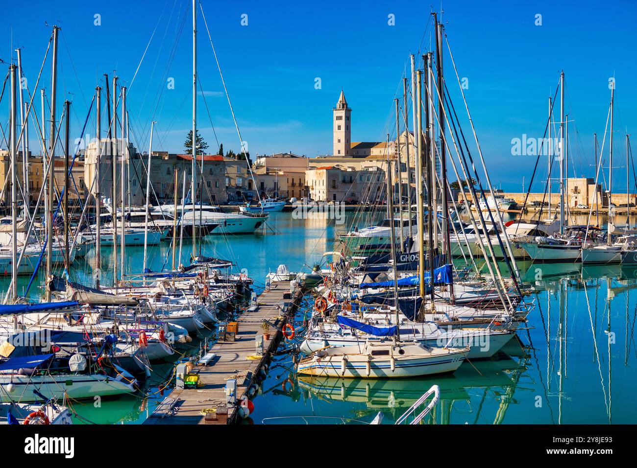 Le vieux port de Trani, en Italie, abrite des yachts et des bateaux de pêche, entourés de bâtiments historiques et du cathedral​ Banque D'Images