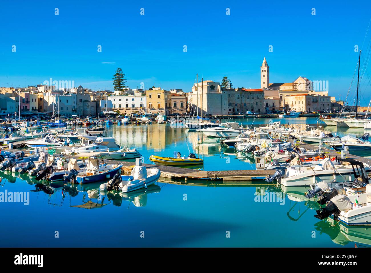 Le vieux port de Trani, en Italie, abrite des yachts et des bateaux de pêche, entourés de bâtiments historiques et du cathedral​ Banque D'Images