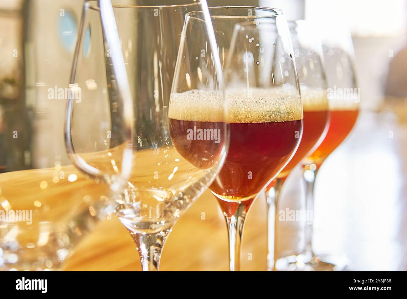 Diversité des types de bière sur une rangée de verres pleins et de verres vides. Banque D'Images