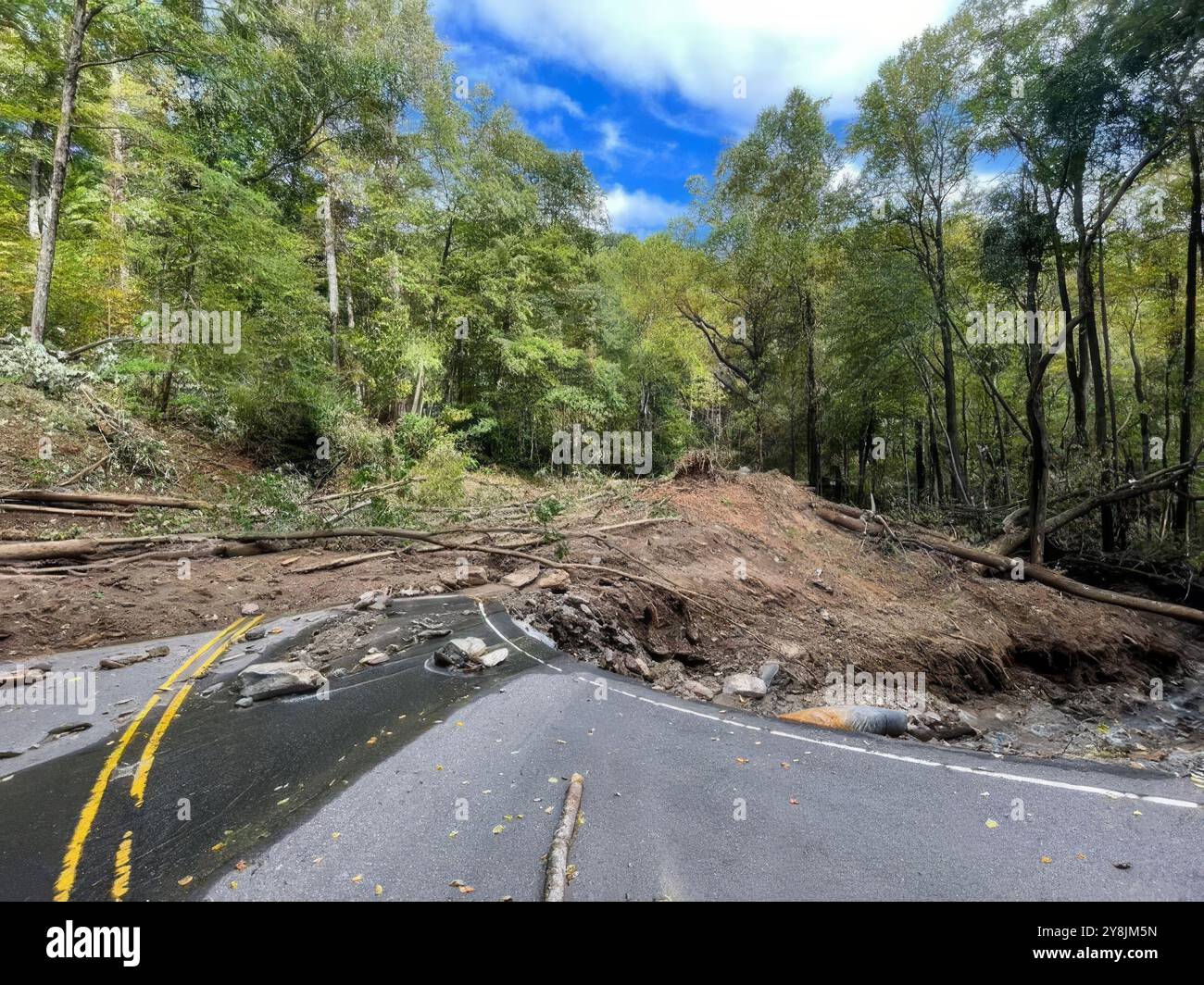 Comté de McDowell, États-Unis. 03 Oct, 2024. North Carolina Highway 80, une route de montagne à deux voies reliant les villes le long des montagnes Blue Ridge, maintenant recouverte de boue et de débris avec de grandes sections emportées par les inondations causées par l'ouragan Helene, le 3 octobre 2024 dans le comté de McDowell, Caroline du Nord. U. Les aviateurs du 118e escadron des opérations de soutien aérien tentent de traverser la route pour dégager une piste pour les secours d'urgence. Crédit : TSGT. Caroline J. Willingham/US Air Force photo/Alamy Live News Banque D'Images