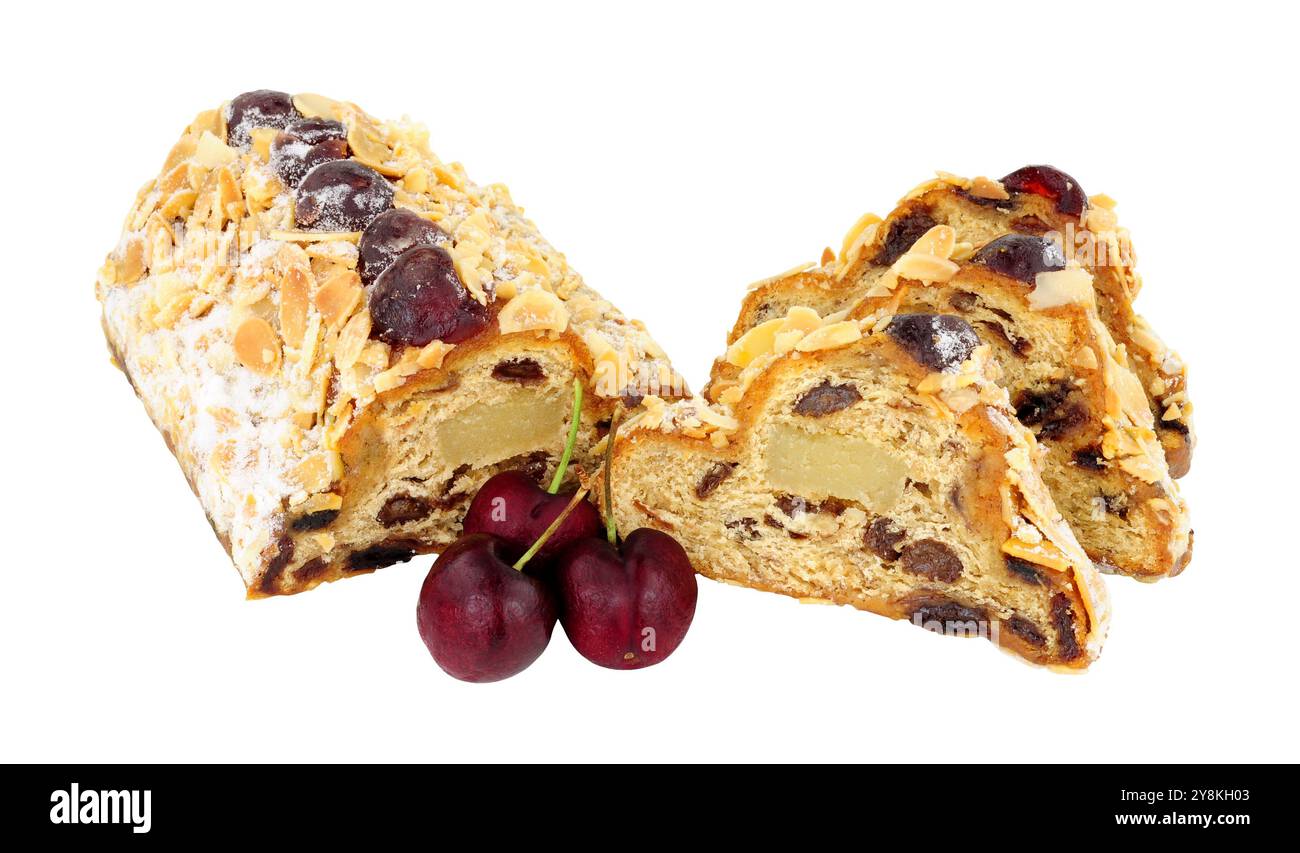 Gâteau aux fruits stollé aux cerises et aux amandes rempli de raisins secs et de massepain et décoré de cerises glacées et d'amandes effilées isolé sur fond blanc Banque D'Images