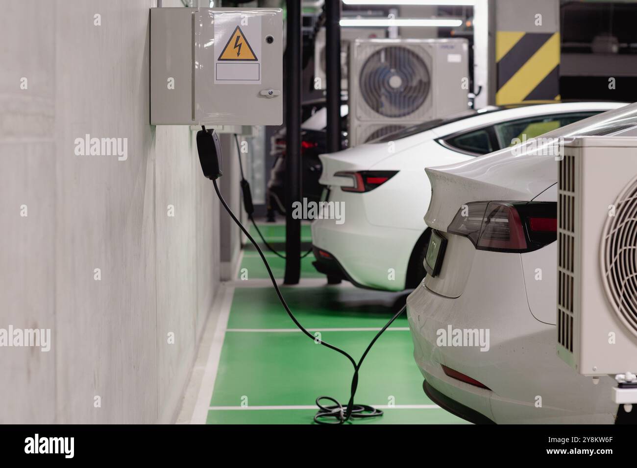 Poznan, Grande Pologne Voïvodie, Pologne, 09.26.2024 voitures électriques se chargeant dans le parking souterrain Banque D'Images