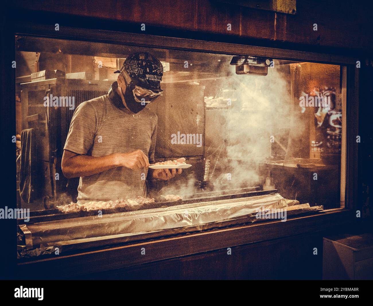 Chef japonais masqué griller de la viande à Tokyo Banque D'Images