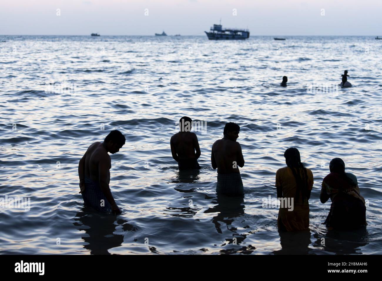 Pèlerins hindous prendre un bain sacré dans la mer devant le lever du soleil à Ghat Agni Theertham, Rameswaram ou Rameshwaram, île de Pamban, Tamil Nadu, Inde, ASI Banque D'Images