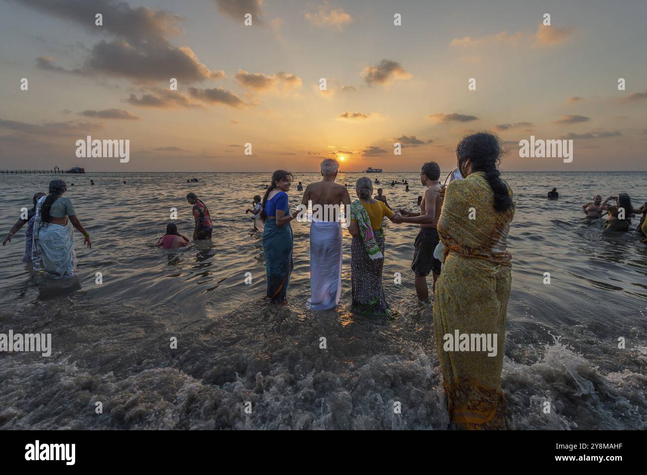 Pèlerins hindous prendre un bain sacré dans la mer au lever du soleil à Ghat Agni Theertham, Rameswaram ou Rameshwaram, île de Pamban, Tamil Nadu, Inde, Asie Banque D'Images