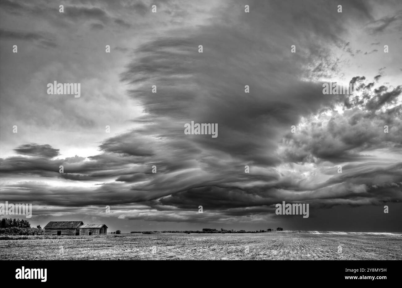 Ferme abandonnée avec les nuages de tempête dans les Prairies canadiennes Banque D'Images
