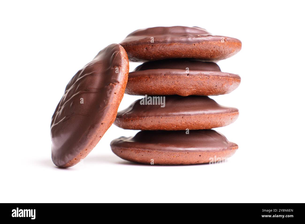 Pile de biscuits ronds recouverts de chocolat sur fond blanc, mettant en valeur leur texture riche et leur revêtement brillant. Parfait pour les thèmes desserts et collations. Banque D'Images