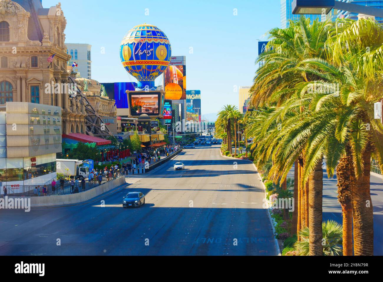 Las Vegas, Nevada - 13 avril 2024 : vue sur le Strip de Las Vegas avec palmiers, panneaux d'affichage emblématiques et circulation légère. Banque D'Images