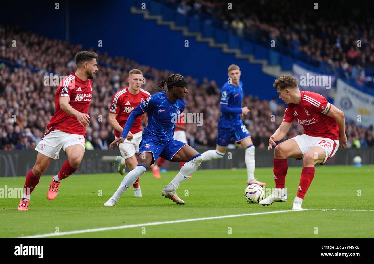 Noni Madueke de Chelsea affronte Ryan Yates de Nottingham Forest (à droite) lors du match de premier League à Stamford Bridge, Londres. Date de la photo : dimanche 6 octobre 2024. Banque D'Images