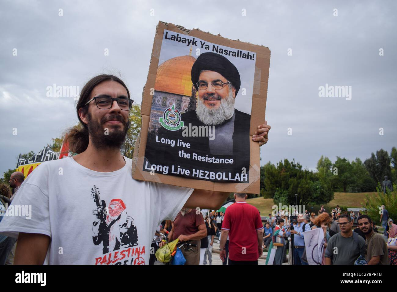 Athènes, Grèce. 5 octobre 2024. Un manifestant tient une pancarte avec le visage de Hassan Nasrallah qui dit, ''Labayk ya Nasrallah! Vive la résistance, vive le Hezbollah.'' Des centaines de manifestants ont défilé dans les rues d’Athènes contre les guerres et en solidarité avec le Liban et la Palestine. Crédit : Dimitris Aspiotis/Alamy Banque D'Images