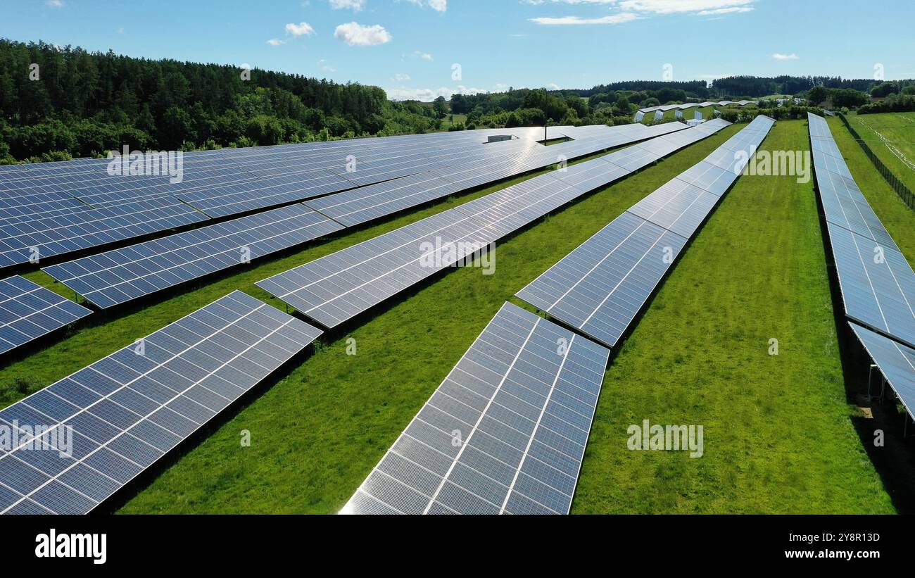 Cette vue aérienne époustouflante capture un vaste champ solaire, mettant en valeur une vaste gamme de panneaux solaires exploitant l'énergie du soleil. La grille ordonnée reposait Banque D'Images