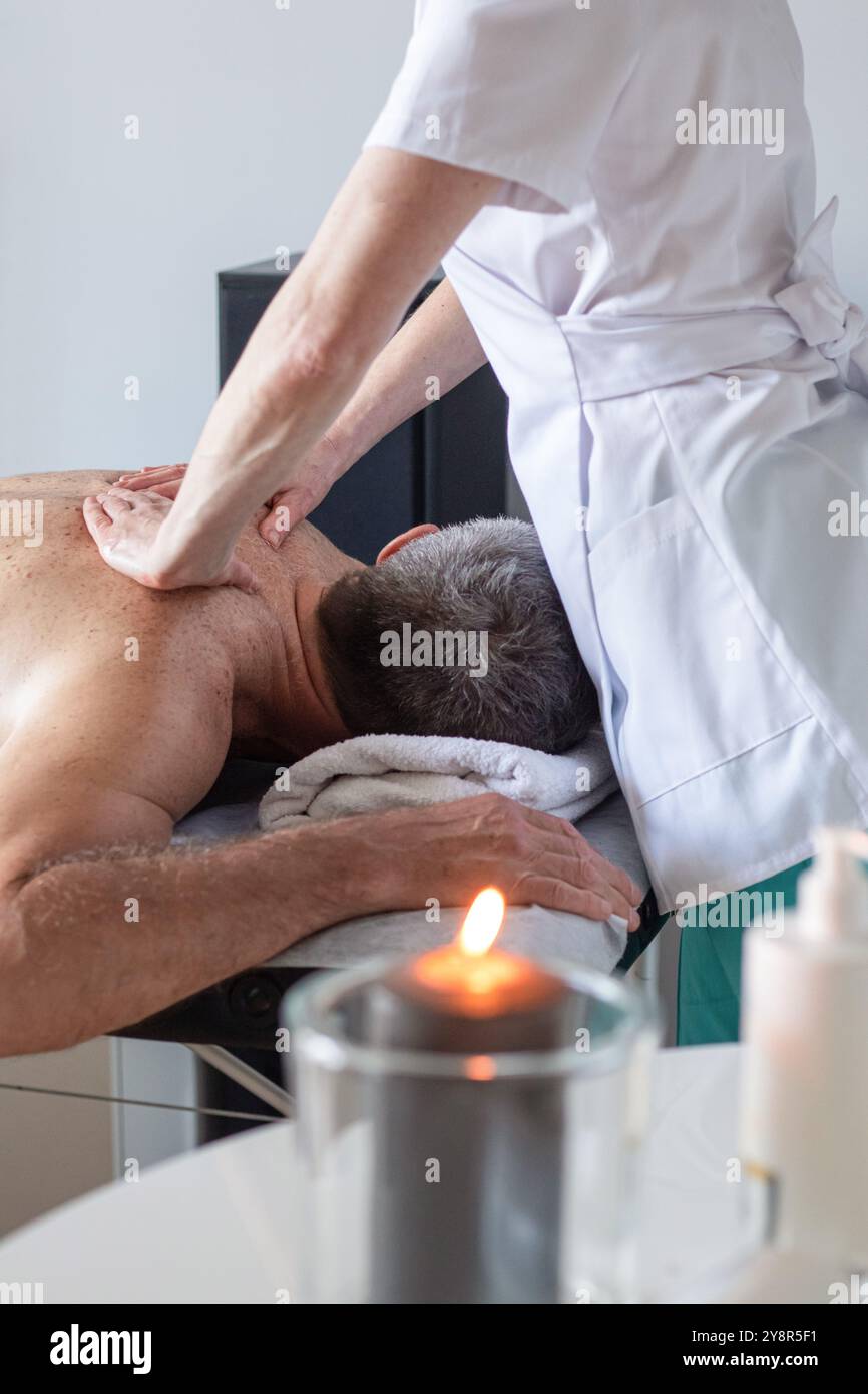 Man receiving massage dos de masseur à spa Banque D'Images