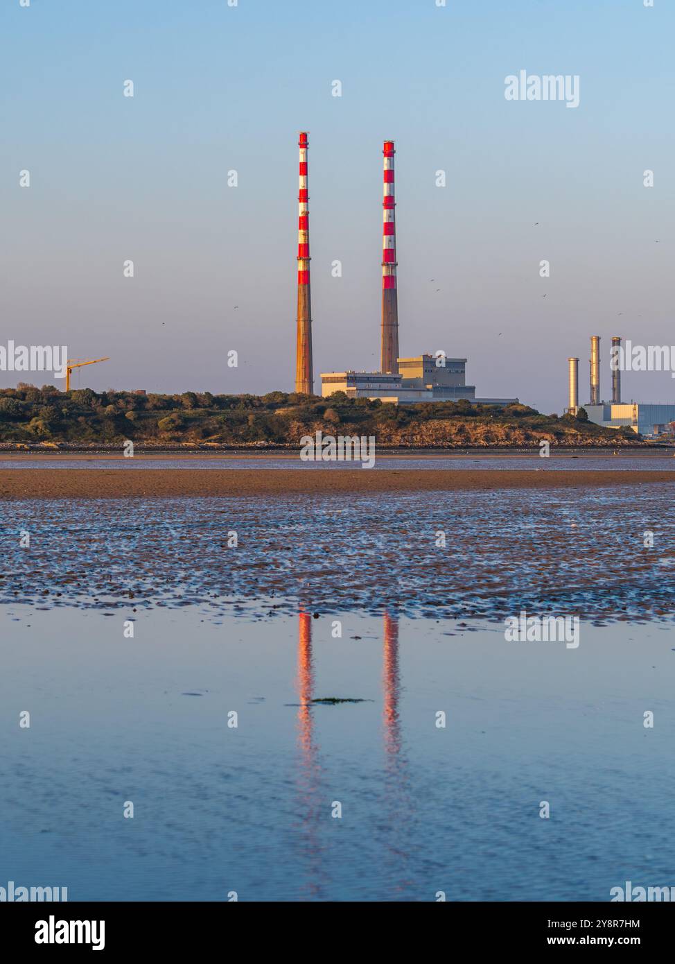 Les cheminées Poolbeg se reflétaient sur Sandymount Strand à l'heure d'or avec leur nouvelle couche de peinture Banque D'Images