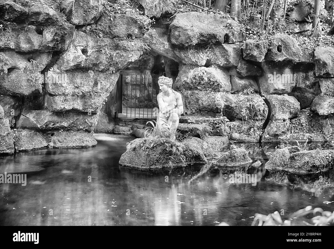 CASERTE, ITALIE - 1er AVRIL 2024 : statue mystique surplombe un étang serein dans les jardins luxuriants du Palais Royal de Caserte Banque D'Images