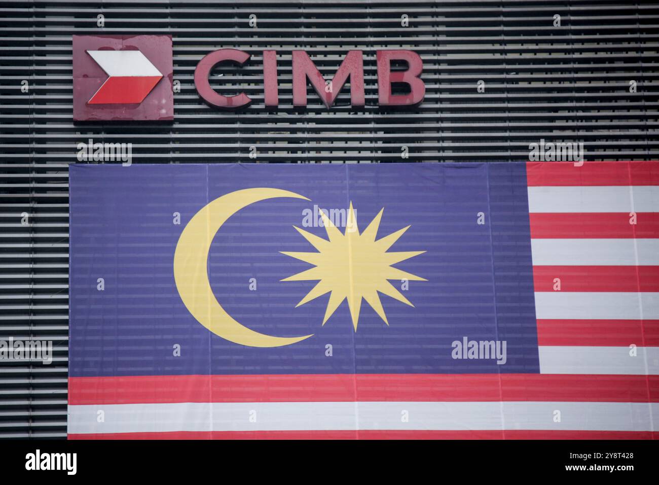Logo de la banque CIMB vu à côté d'un drapeau de la Malaisie à Kuala Lumpur. Marque et logo vus à Kuala Lumpur. Banque D'Images