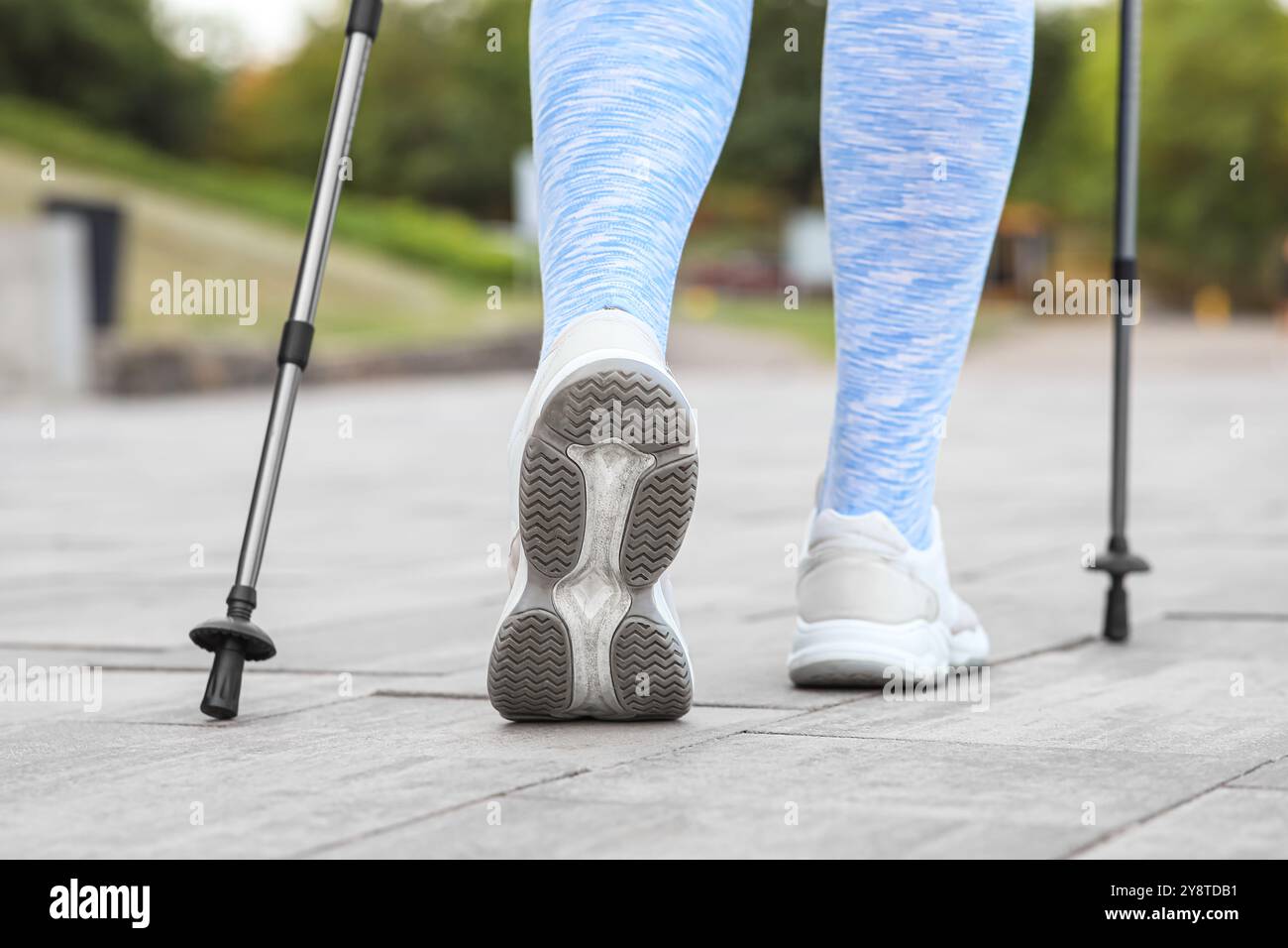 Femme sportive faisant de la marche nordique dans la rue, vue arrière Banque D'Images