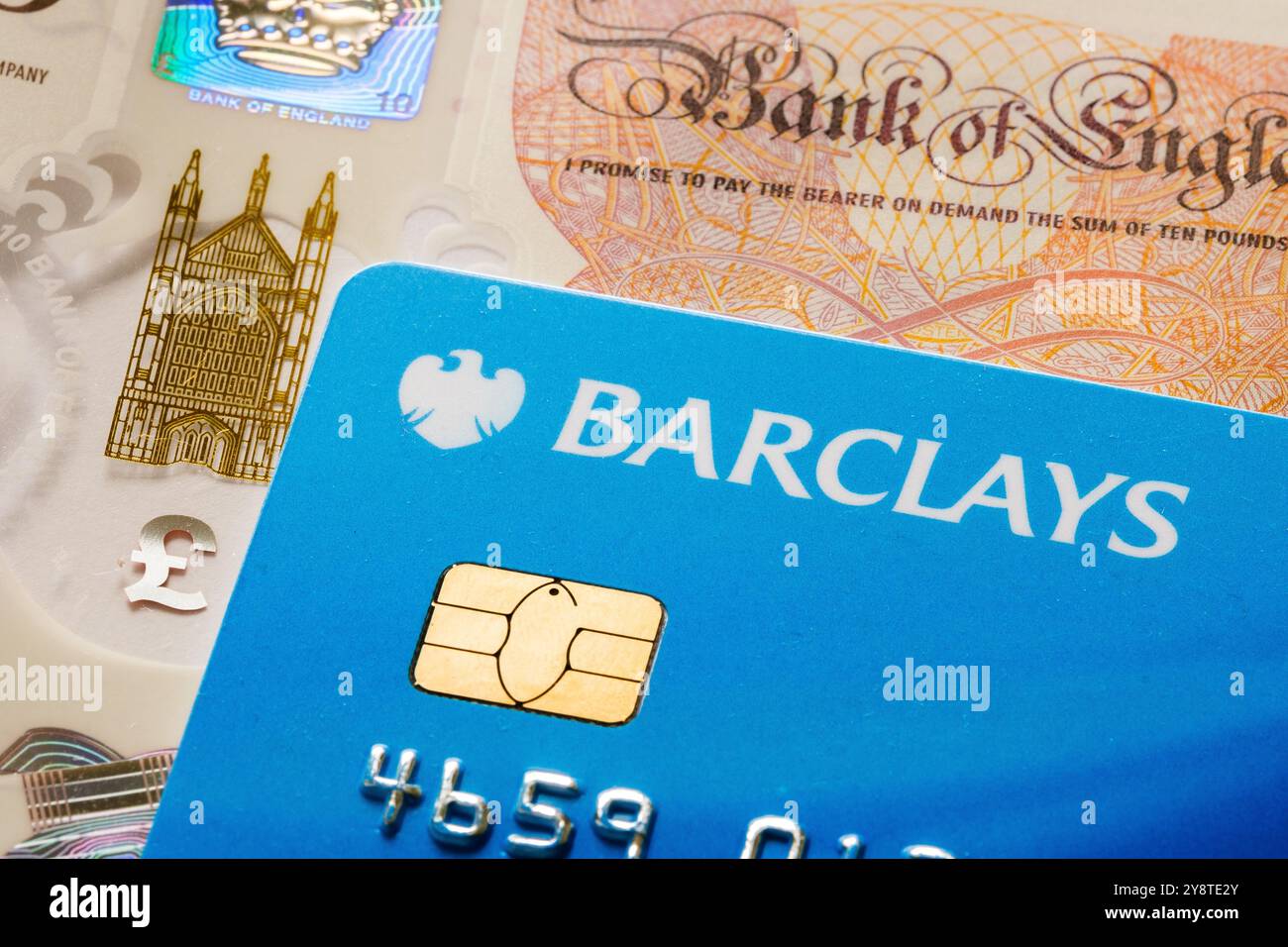 Gros plan sur la carte de débit Barclays avec monnaie britannique. Concept financier mettant en avant les services bancaires, le change de devises et les paiements numériques. Stafford Banque D'Images