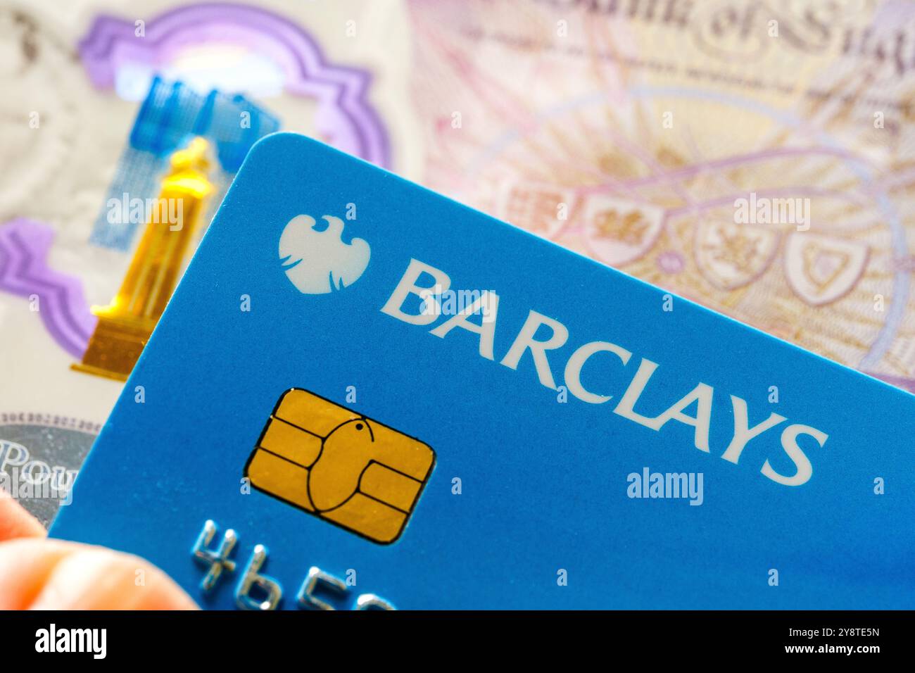 Gros plan sur la carte de débit Barclays avec fond de monnaie britannique. Mettre en avant les services bancaires numériques, les paiements sécurisés et les solutions financières. Staffo Banque D'Images