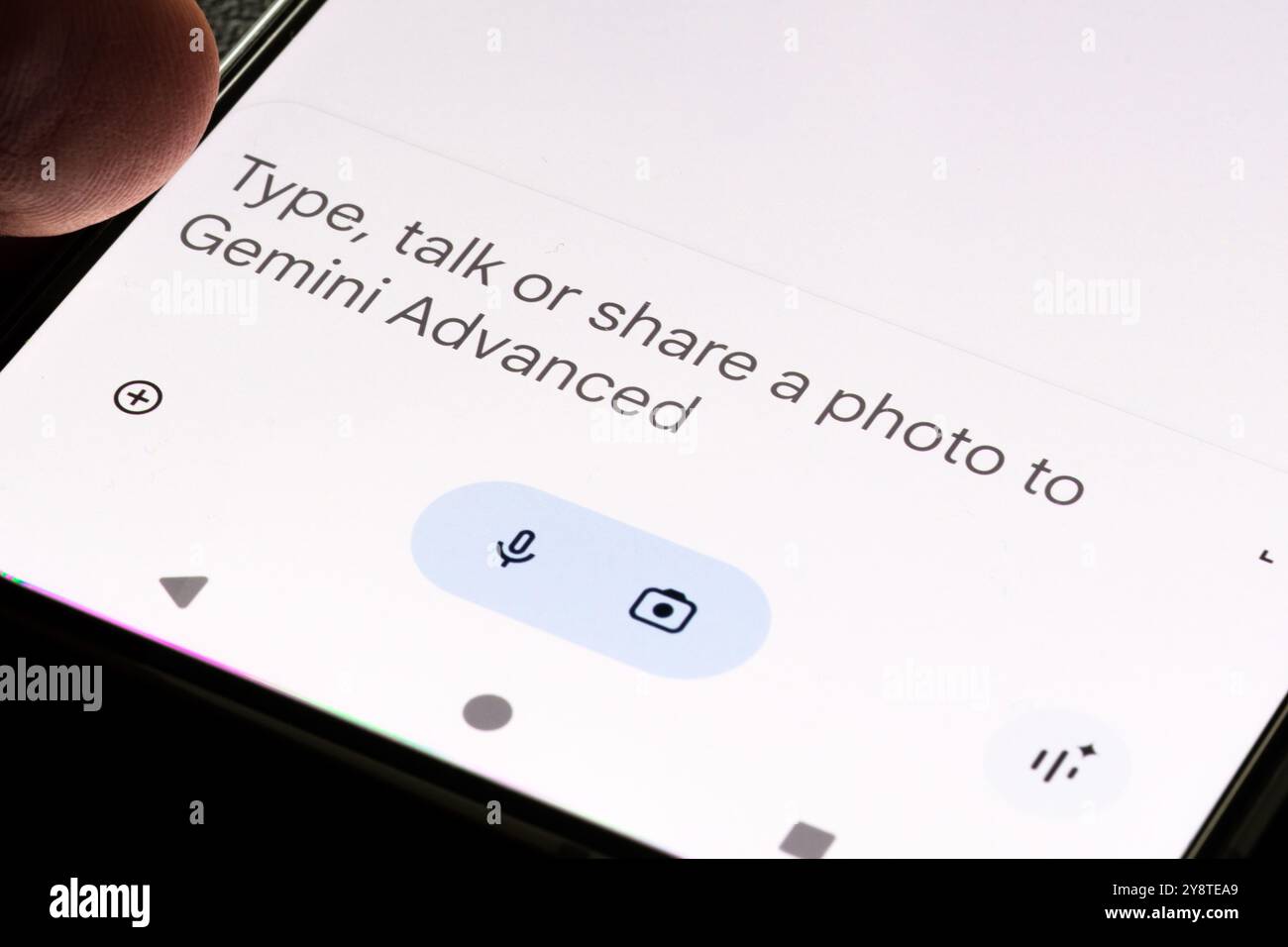 Gros plan d'une interface de smartphone montrant l'invite de Gemini Advanced IA encourageant l'interaction de l'utilisateur via la saisie, la conversation ou le partage de photos. Banque D'Images