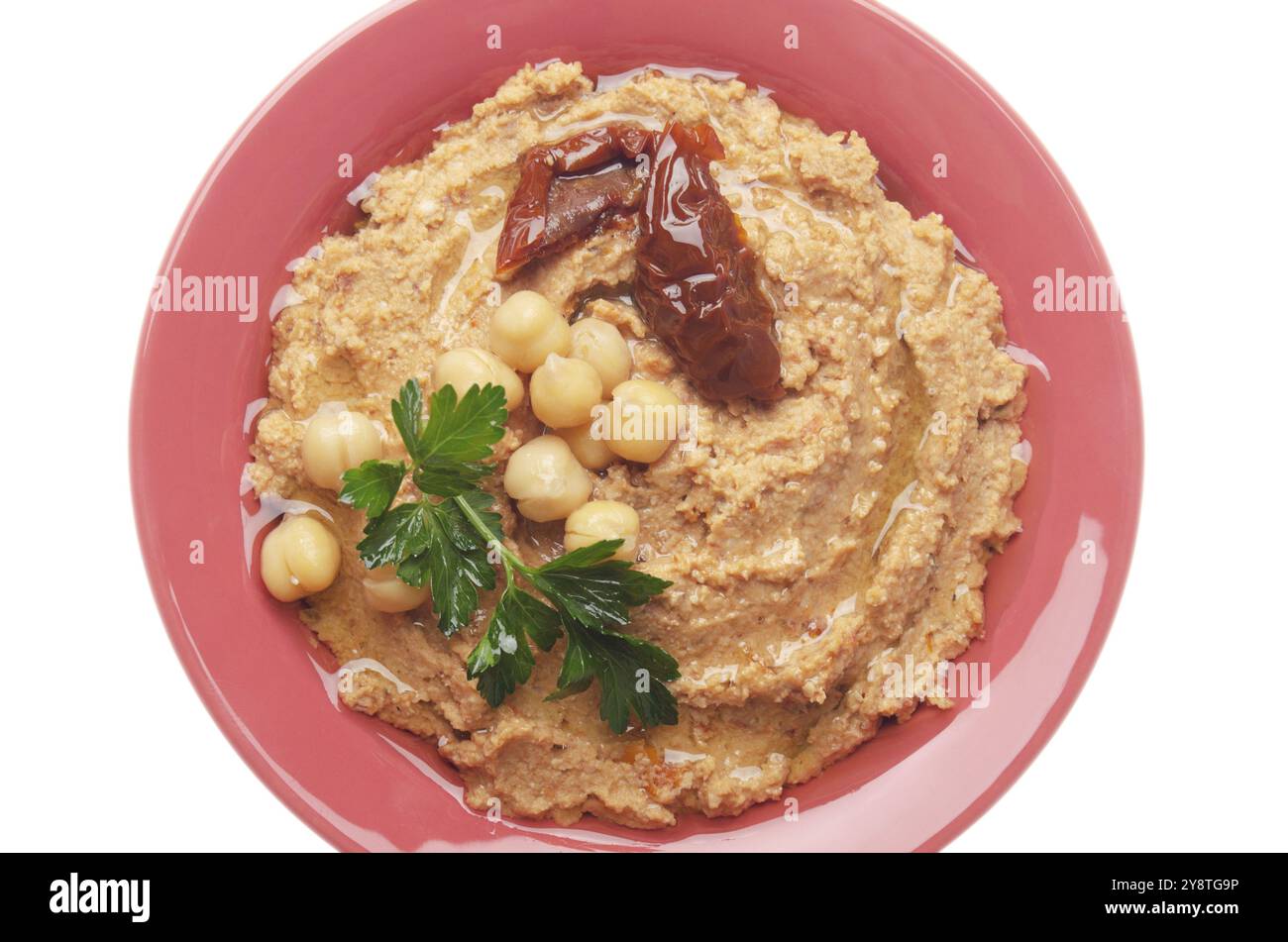 Vue sur la couche plate du houmous recouvert de haricots, de tomates séchées et de feuilles de coriandre verte isolées sur fond blanc. Masque ajouté Banque D'Images