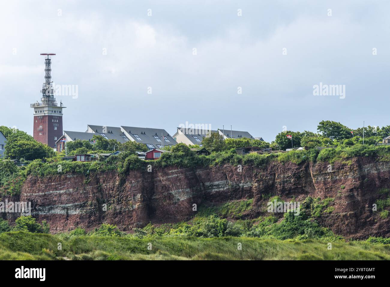 Falaise de grès de couleur rouge sur l'île de haute mer de Heligoland, lotissements sur le bord de la falaise dans l'Oberland, phare de briques, mer du Nord, Pinnebe Banque D'Images