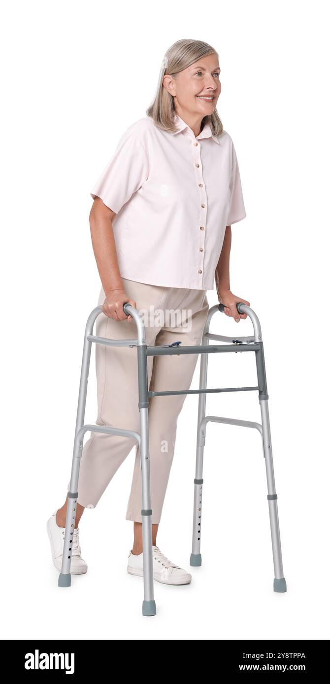 Femme senior utilisant le cadre de marche sur fond blanc Banque D'Images