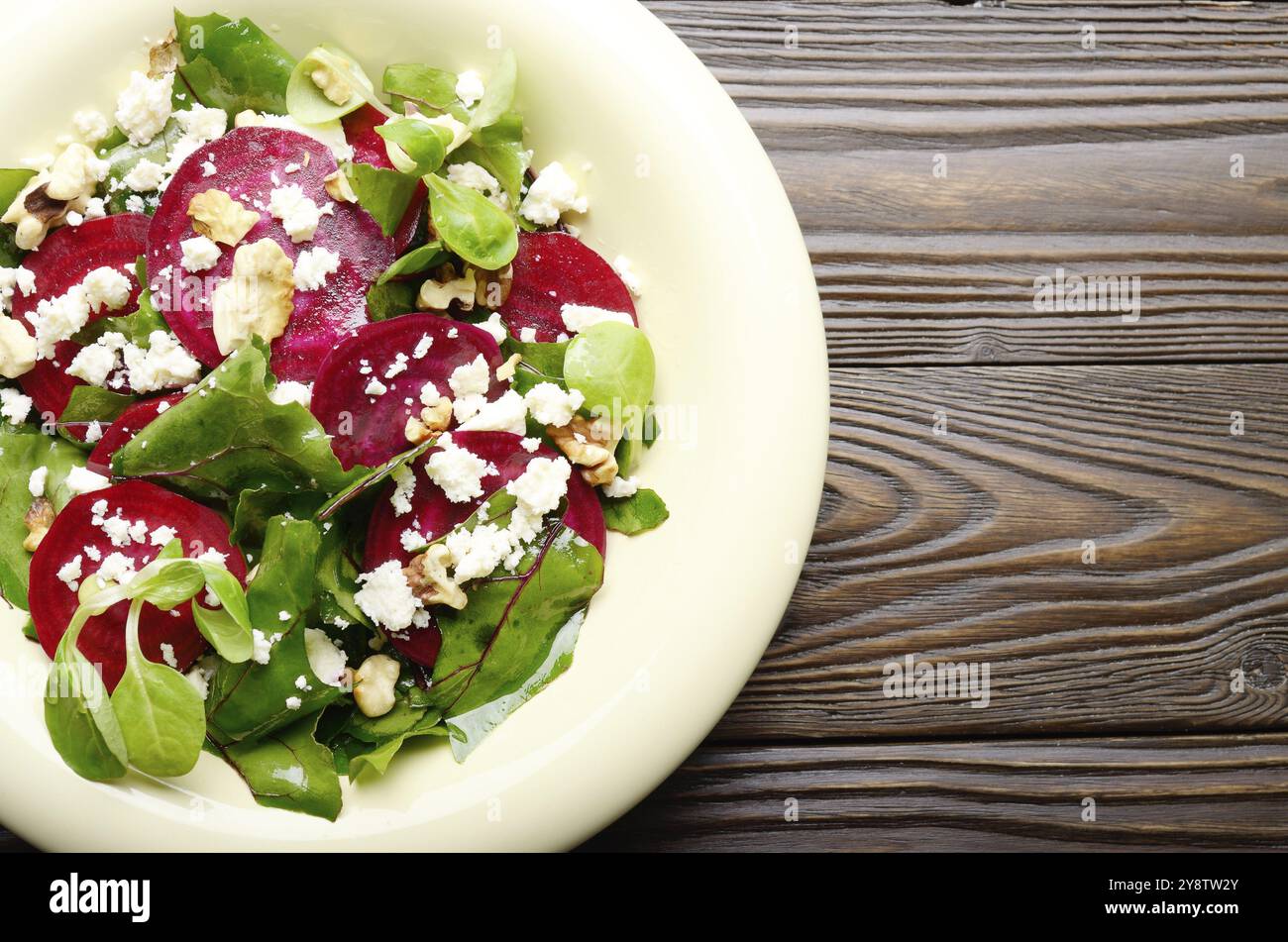 Vue supérieure de la méditerranée au noix grillées salade de fromage feta et écraser les feuilles sur la table en bois Banque D'Images