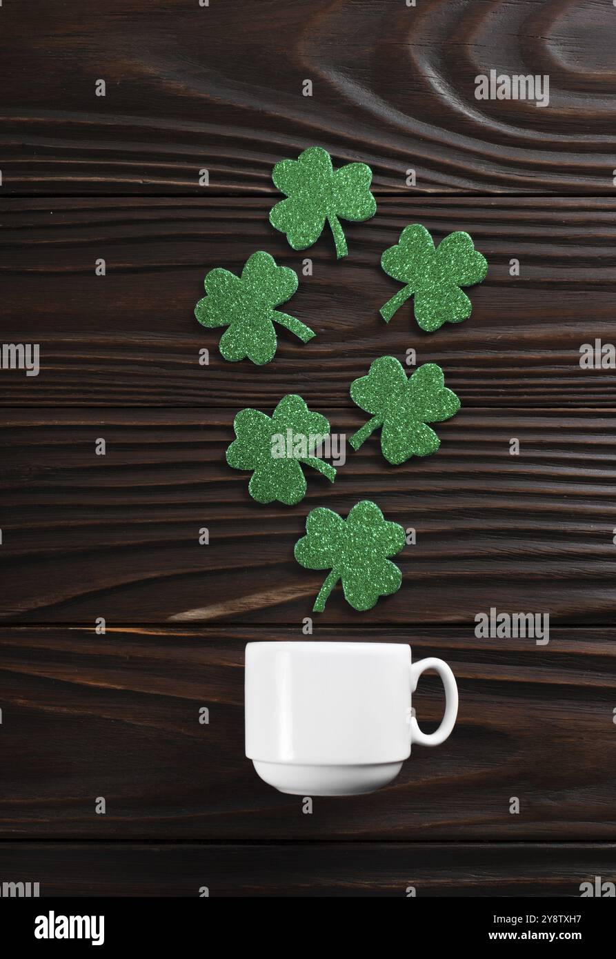 Tasse à café avec trois feuilles de shamrock faites à la main sur fond de bois Banque D'Images