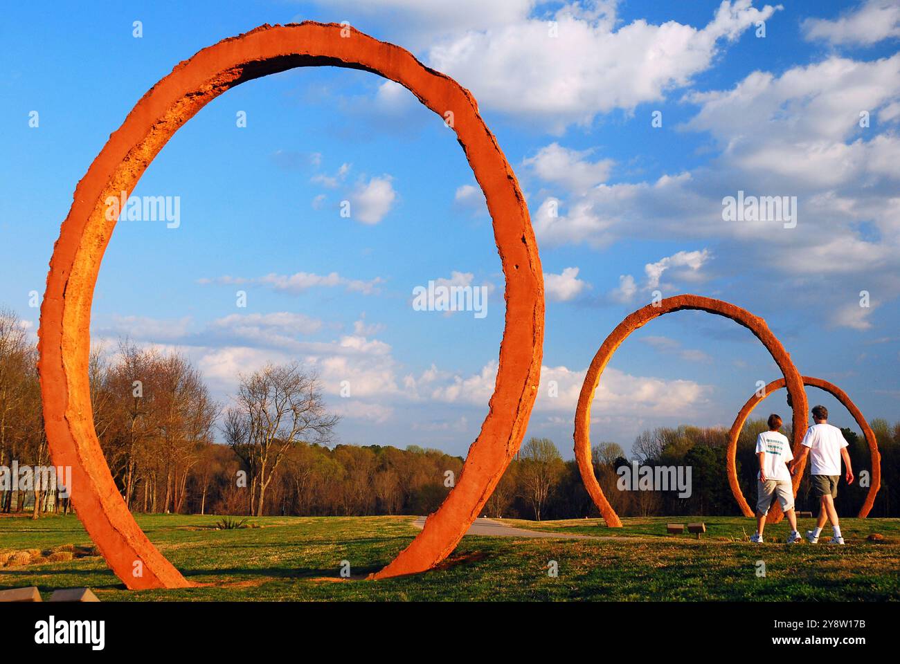 Un jeune couple marche pas dans les grands cercles du Gyre de Thomas Sayre sur le terrain de sculpture du North Carolina Museum à Raleigh Banque D'Images