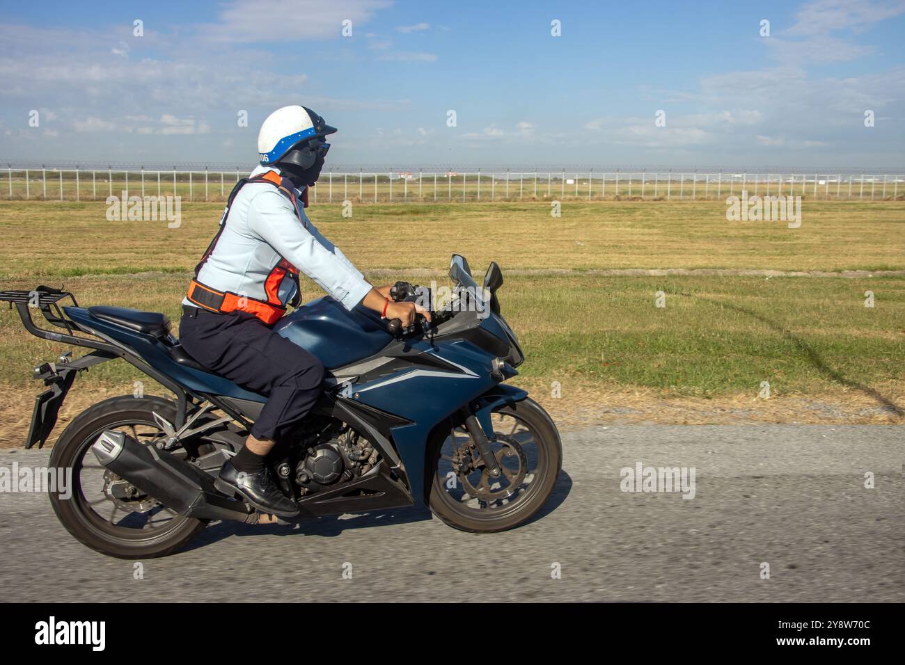 Le service de sécurité aéroportuaire fait le tour de l'aéroport clôturé sur une moto, Bangkok, Thaïlande Banque D'Images