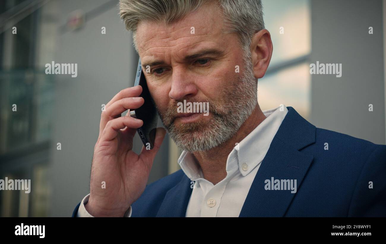 Caucasien vieil homme d'affaires retraité homme d'affaires senior mature dirigeant employeur parlant smartphone mobile mis sur lunettes fin appel de finition mettant le téléphone dedans Banque D'Images